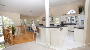 A spacious kitchen with a central island, white cabinetry, and large windows. - Soundside, Community Amenities, Sun Decks, 327, Footprints by the Sound (Corolla)