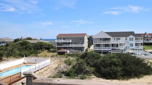 A beachfront property with multiple-story houses, a swimming pool, and a sandy beach. - Oceanside, Private Pool, Sun Decks, 660 ft to beach access! -WW951, Momma's Happy, Daddys Broke (Corolla)