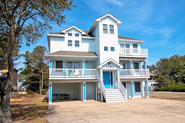 A two-story house with a balcony on the second floor, a front door, and a garage.