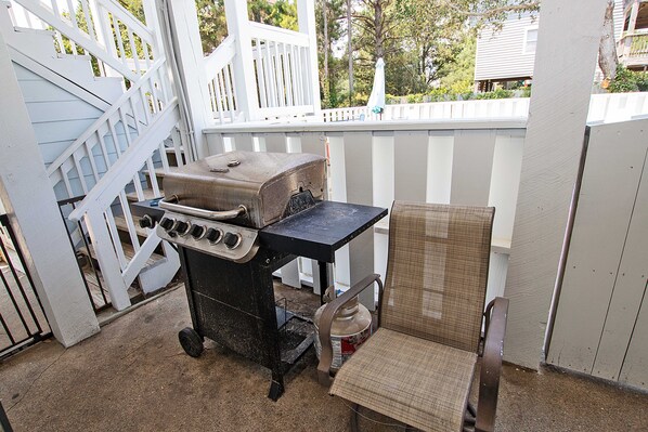 Eine Terrasse mit Grill und einem Stuhl.