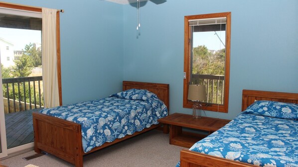 A room with two wooden beds, a small table, a mirror, and a sliding door to a balcony. - Oceanside, Private Pool, Hot Tub, Screened Porch, 650 ft to Beach Access, WW1021, Zip-A-Dee-Dune-Dah (Corolla)