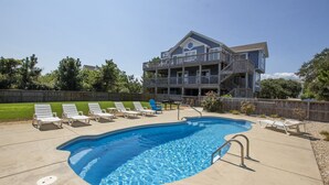 A two-story building with a pool, lounge chairs, and a wooden deck. - Oceanside, Private Pool, Hot Tub, Screened Porch, 650 ft to Beach Access, WW1021, Zip-A-Dee-Dune-Dah (Corolla)