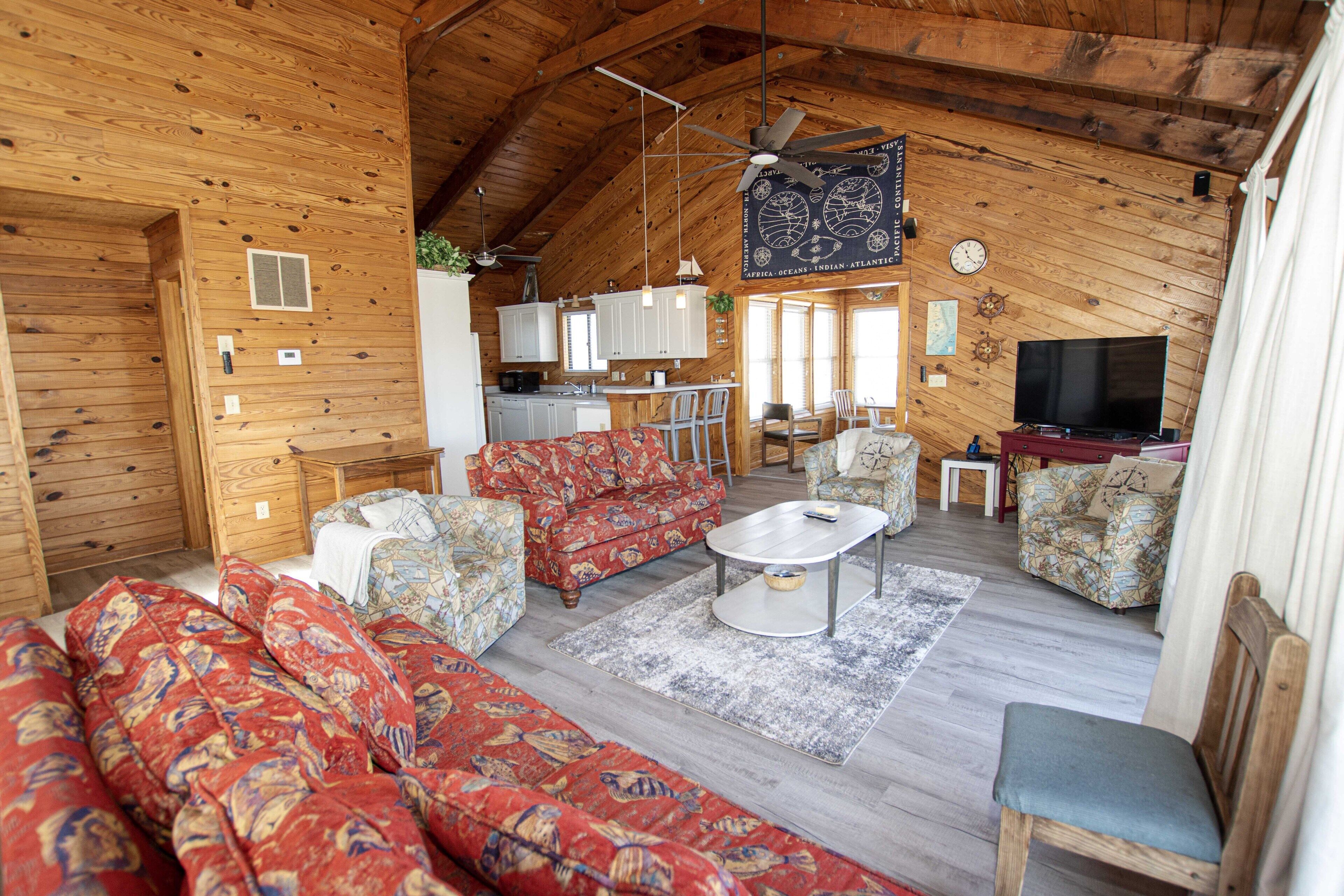 A cozy cabin interior with a living room, dining area, and kitchen.