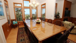 A spacious dining area with a large wooden table, multiple chairs, and a chandelier. - Oceanside, 7 BRs, ELEVATOR, Private Pool, Hot Tub, OH3, Aurora (Corolla)