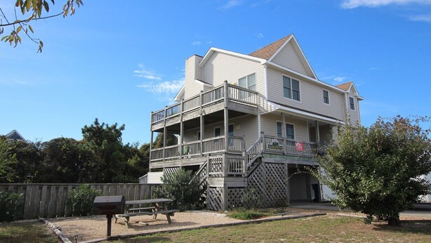 A two-story building with a balcony and a covered porch.