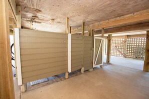 A room with a wooden ceiling, a concrete floor, and a large wooden partition. - Oceanside, Private Pool, Hot Tub, Close to beach access, 224, Its All Good (Corolla)