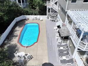 An aerial view of a residential property with a swimming pool, white deck chairs, and a covered patio area. - Oceanside, Private Pool, Hot Tub, Close to beach access, 224, Its All Good (Corolla)
