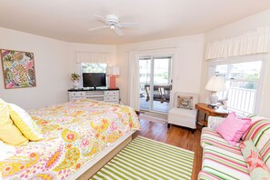 A bedroom with a bed, a TV, a dresser, a window, and a balcony. - Oceanside, Private Pool, Hot Tub, Close to beach access, 224, Its All Good (Corolla)