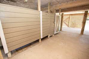 Une pièce dotée d’un plancher en bois, de murs de couleur beige et d’une porte entrouverte donnant sur un autre espace.