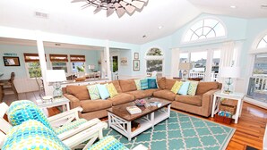A spacious living room with a large sectional sofa, a coffee table, and a patterned rug.
