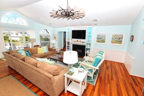 A spacious living room with a large sectional sofa, a fireplace, and a ceiling fan. - Oceanside, Private Pool, Hot Tub, Close to beach access, 224, Its All Good (Corolla)