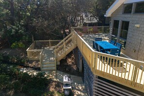 Eine Holzterrasse mit einer Treppe, die zu einem Haus führt.