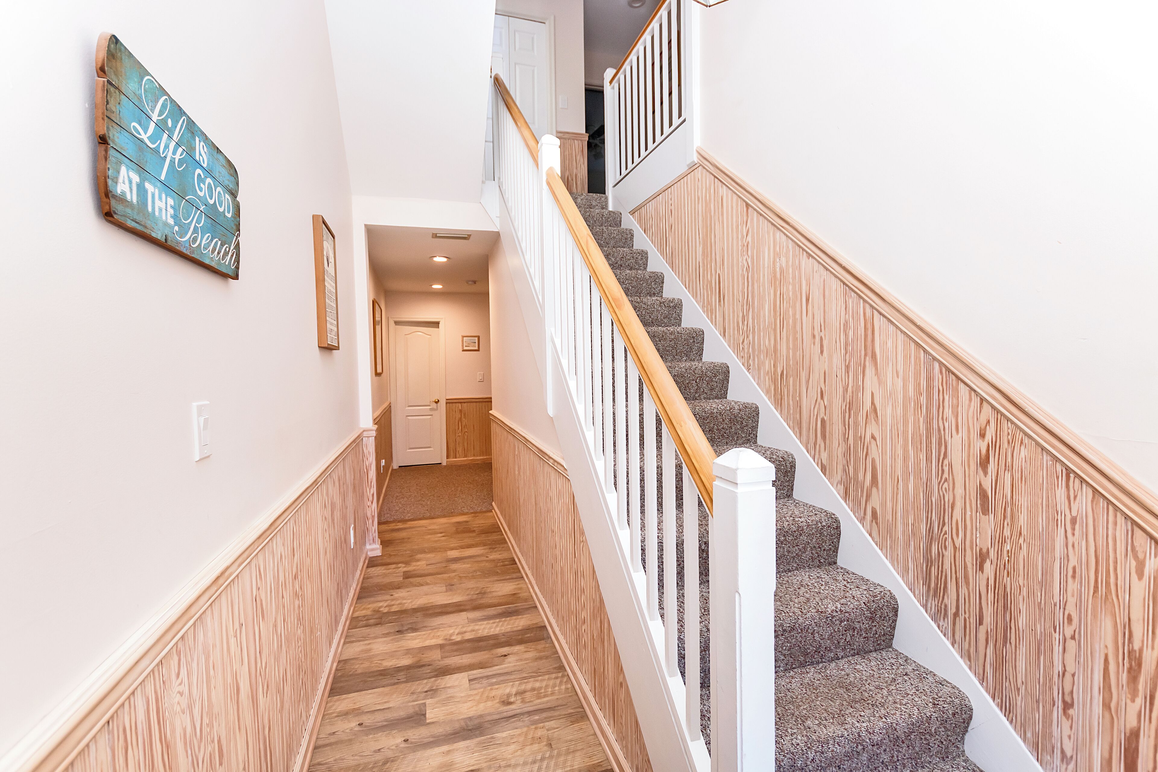A staircase with wooden railings and carpeted steps leading to an upper floor.