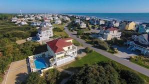 A coastal residential area with houses, a swimming pool, and a view of the ocean. - Oceanside, Private Pool, Rec Room, Vllyball, PI157, Vintage Pine (Corolla)