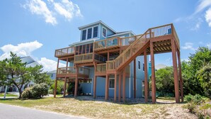 A two-story house with a wooden deck and stairs leading to a balcony. - Oceanside, easy walk to Beach, Hot Tub, Dogs Welcome, OL4, Lakes Ocean View (Corolla)