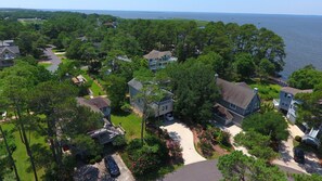 A residential area with houses surrounded by trees and a body of water in the background. - Semi-Soundfront, Rec Room, Community Amenities, 533,Sound Secret (Corolla)