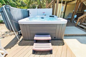 Un bain à remous avec une terrasse en bois, une piscine couverte et une clôture en bois.