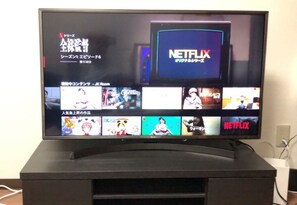 Uma televisão exibindo a interface da Netflix com diversas opções de conteúdo.