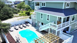 A multi-story building with a swimming pool, outdoor seating, and a covered patio area. - Oceanside, Pool, Hot Tub, 945 ft to Beach Access, WW935, Sea Watch (Corolla)