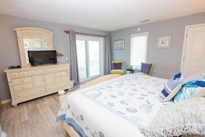A bedroom with a bed, dresser, television, and a window with curtains. - Oceanside, Pool, Hot Tub, 945 ft to Beach Access, WW935, Sea Watch (Corolla)