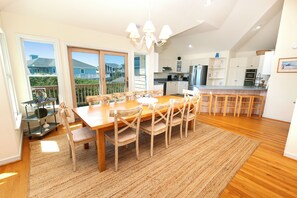A spacious kitchen with a dining area, large windows, and a view of the outside. - Oceanside, Private Pool, Hot Tub, Close to the Beach Access, 225, Glory Be (Corolla)