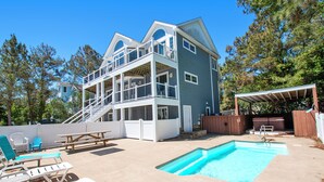 A two-story house with a swimming pool, outdoor seating, and a covered patio. - Oceanside, Private Pool, Hot Tub, Pool Table, Dogs Welcome, WC1084, Oaks Beach Oasis (Corolla)