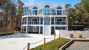 A multi-story building with balconies, a covered patio, and a view of the surrounding trees. - Oceanside, Private Pool, Hot Tub, Pool Table, Dogs Welcome, WC1084, Oaks Beach Oasis (Corolla)
