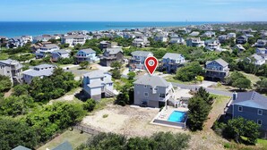 A residential area with houses, a swimming pool, and a pier in the background. - Oceanside, Private Pool, Hot Tub, Community Pool, CD7, Sandfiddler Lodge (Duck)