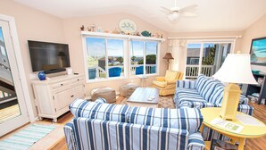 A living room with a television, sofa, and a table with a lamp. - Oceanside, Private Pool, Hot Tub, Community Pool, CD7, Sandfiddler Lodge (Duck)