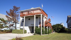 A two-story building with a balcony, a sign reading "SeaShore 10410", and an American flag. - Oceanside, Close to beach, Sunroom, Carport, SNH351, Sea Sharp (Nags Head)