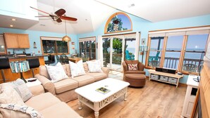 A spacious living area with a large sofa, a coffee table, and a view of the ocean through large windows. - Soundfront, Priv Dock, Sound Views, Sun Deck, SA425, Sound Mind (Duck)
