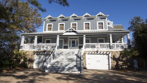 A two-story house with a porch, stone foundation, and a garage. - Soundside, Priv Pool, H Tub, ELEV, Rec Rm, Theatr Rm, FR1, The Drake (Duck)