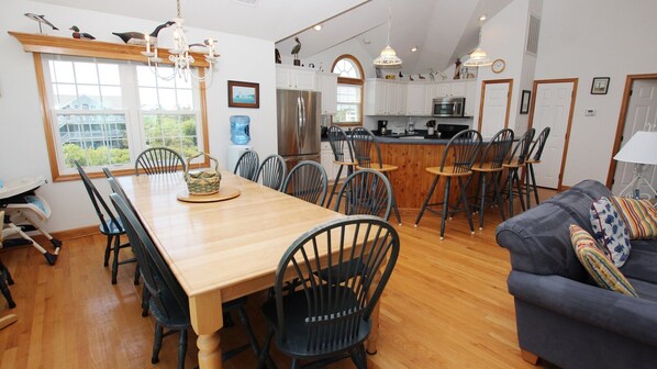 A spacious kitchen with a central island, wooden dining table, and chairs. - Semi-Oceanfront, 7 BRs, Priv Pool, H Tub, Rec Rm, WL1068, Footloose (Corolla)