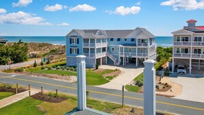A large, multi-story hotel with a coastal view, featuring balconies, a central courtyard, and a parking area. - Semi-Oceanfront, Rec Room, Private Pool, Ocean Views, WL1092, Maritime (Corolla)