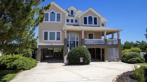 A two-story house with a front porch, garage, and a well-maintained lawn. - Soundside, Pool, Hot Tub, Community Amenities, MS24, Turtle Whispers (Corolla)