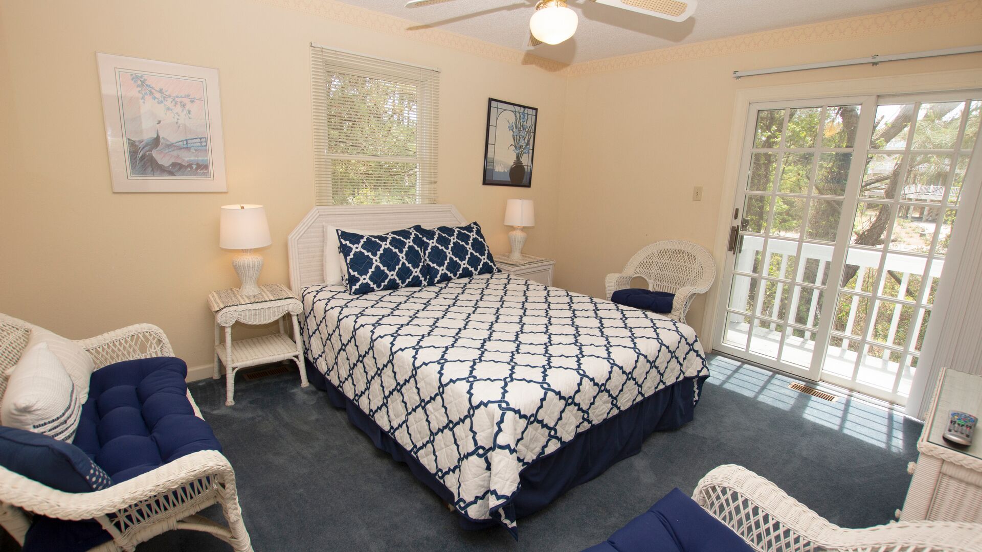 A bedroom with a large bed, two nightstands, a chair, and a window with blinds.