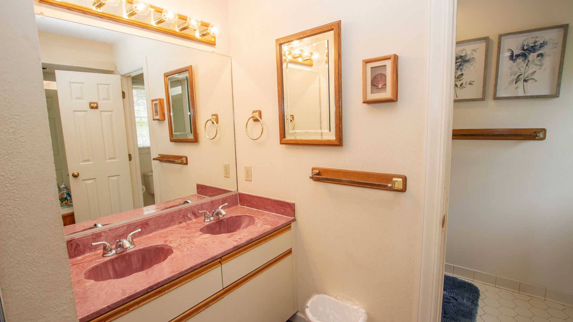 A bathroom with two sinks, a mirror, and a towel rack.