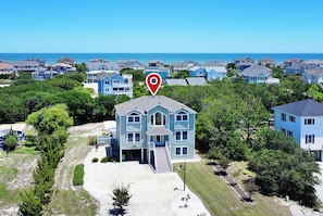 A residential area with houses, a clear sky, and a body of water in the background. - Oceanside, Prv Pool, H Tub, Rec Rm, Sun Decks, WC887, Ashley's Nest (Corolla)