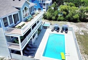 A multi-story building with a swimming pool, outdoor seating, and a deck. - Oceanside, Prv Pool, H Tub, Rec Rm, Sun Decks, WC887, Ashley's Nest (Corolla)