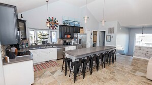 A spacious kitchen with a large island, modern appliances, and a bar seating area. - Oceanside, Pool, Poolside Bar, Sun Decks, WC803, Believing is Sea-ing (Corolla)