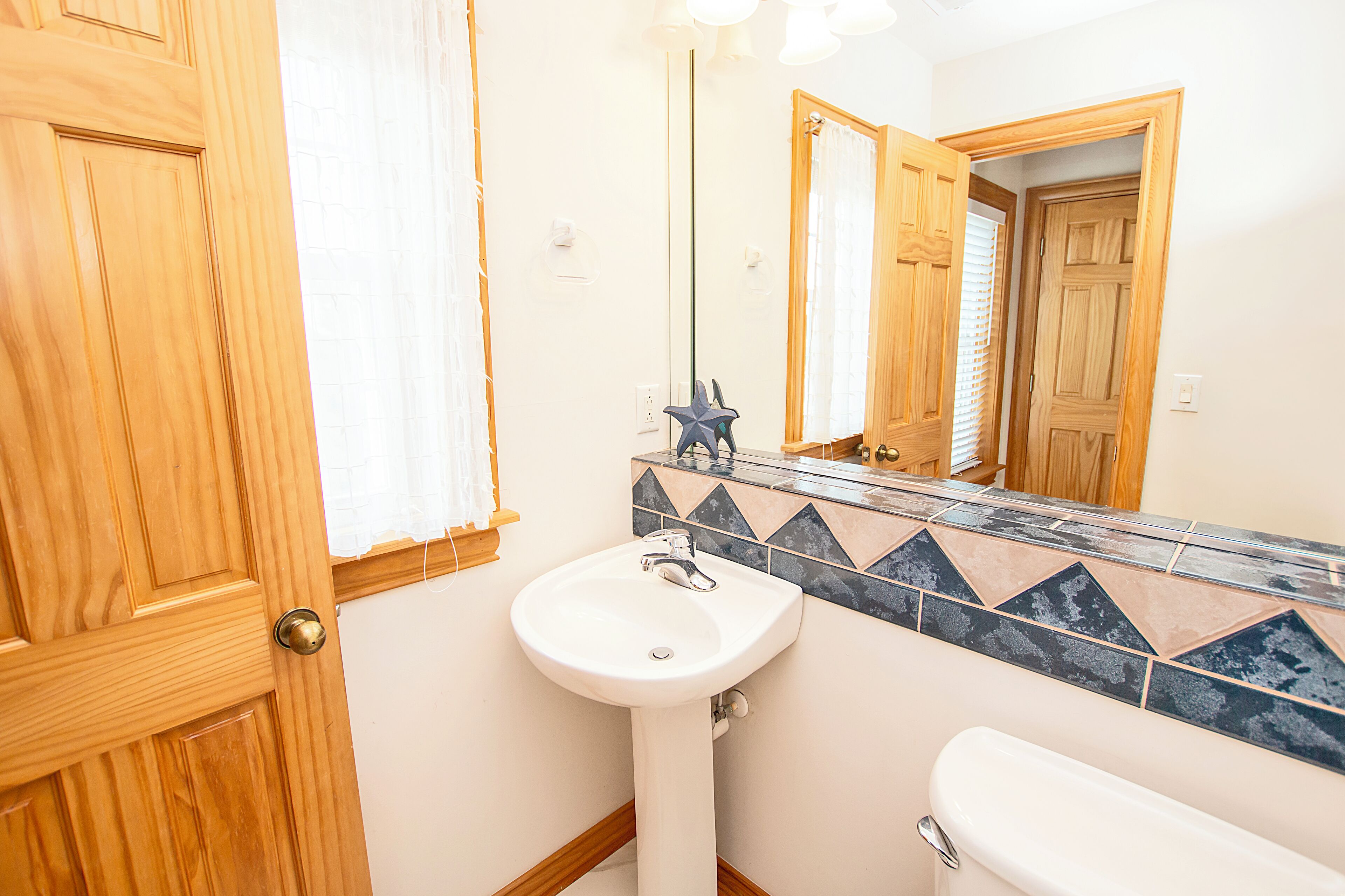 A bathroom with a wooden door, a white sink, and a toilet.