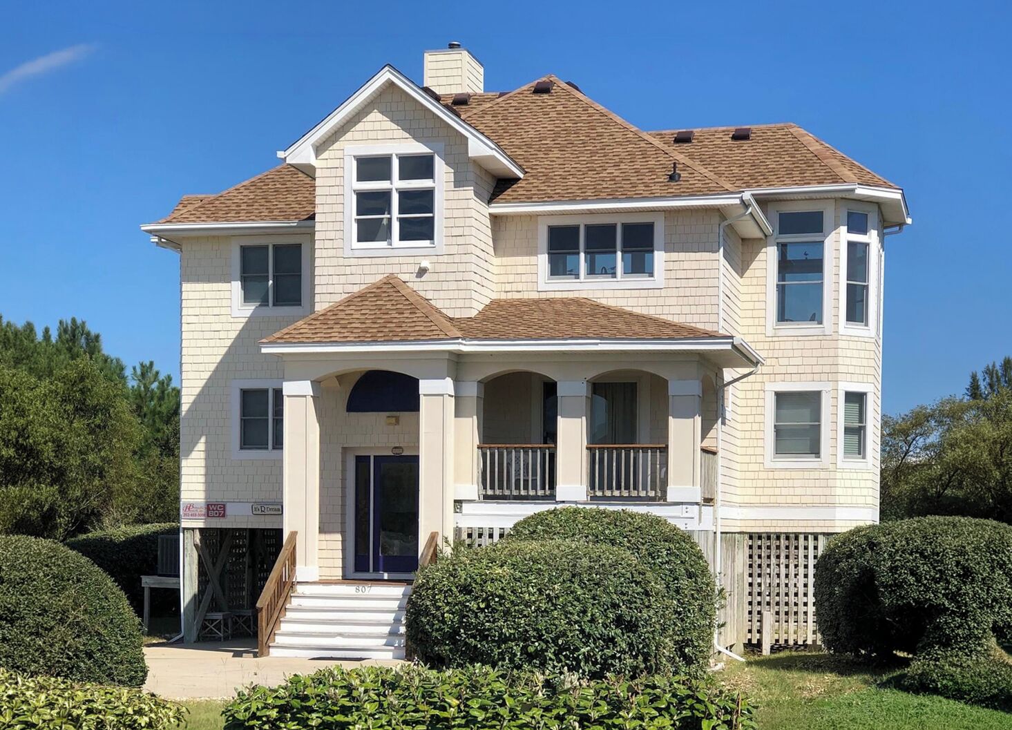 A two-story house with a front porch, a chimney, and a mailbox.