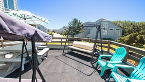 A patio area with a swing chair, a bench, and a table.