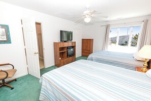 A hotel room with two beds, a television on a wooden stand, a ceiling fan, and a window with curtains. - Oceanside, Community Pool, Community Amenities, 677, Windswept II (Corolla)