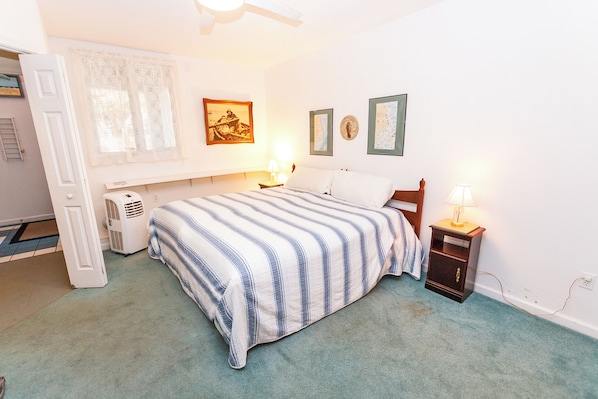 Quarto com cama, luminárias de cabeceira, aquecedor e decorações nas paredes.