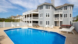 A two-story building with a swimming pool, outdoor seating, and a covered patio area. - Oceanside, 7 BRs, Private Pool, Den, Rec Rm, 350 ft to Beach access, PI54, Fore Sea Suns (Corolla)