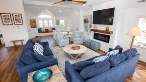 A spacious living room with two sofas, a coffee table, and a fireplace. - Oceanside, 7 BRs, Private Pool, Den, Rec Rm, 350 ft to Beach access, PI54, Fore Sea Suns (Corolla)