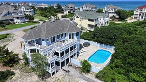 A large house with a pool, surrounded by trees and other houses. - Oceanside, 7 BRs, Private Pool, Den, Rec Rm, 350 ft to Beach access, PI54, Fore Sea Suns (Corolla)