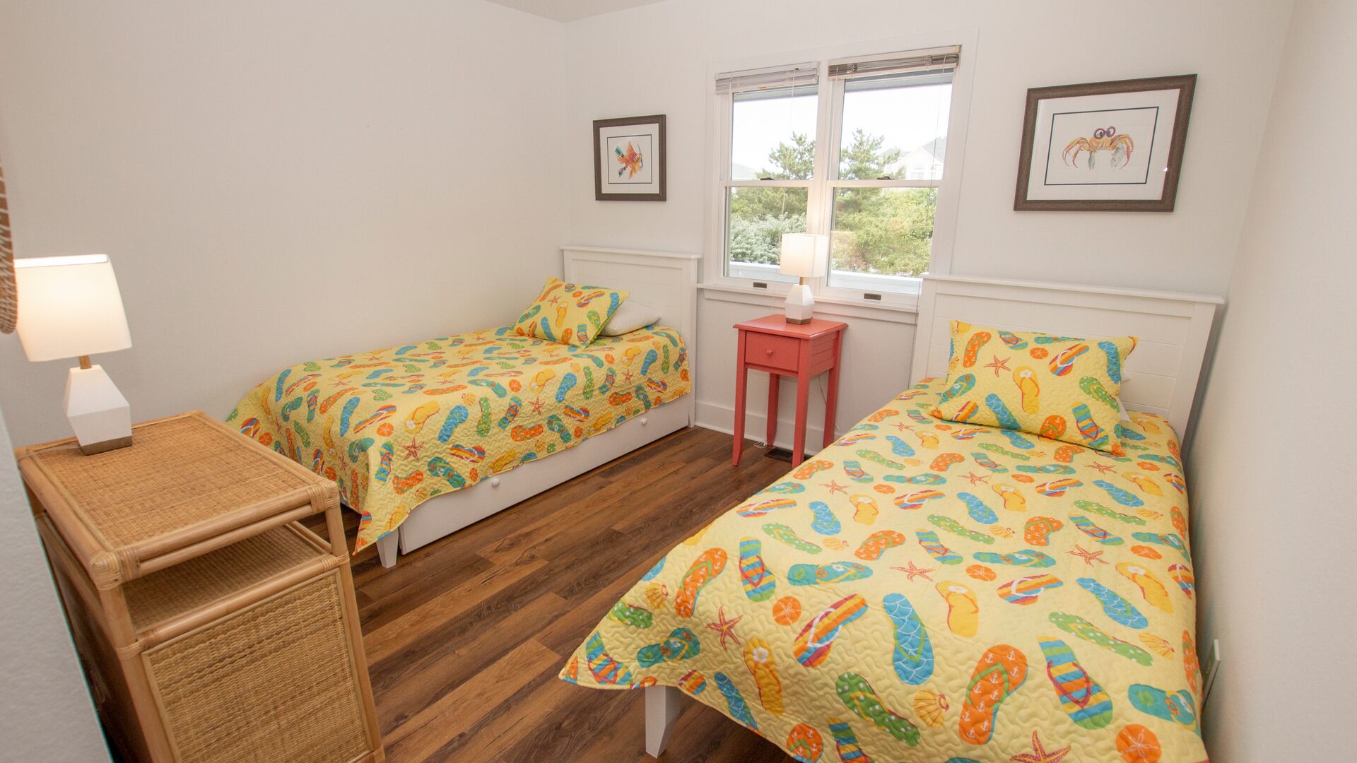 Une chambre avec deux lits simples, une petite table, une lampe et une fenêtre donnant sur un paysage agréable.