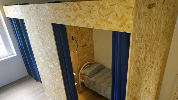 A room with a bunk bed, wooden walls, and blue curtains. - A46 Foresteria Lombarda (Monza)